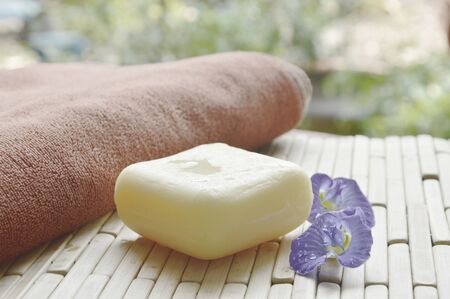soap and towel with blue pea purple flower on bamboo matの写真素材