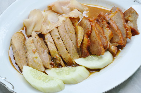roasted duck and sweet barbecue pork in sauce on plateの写真素材