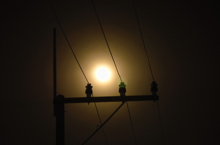 electric pole and cable with full moon background in nightの写真素材