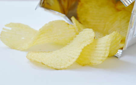 potato chip pouring from aluminium foil packaging on white background