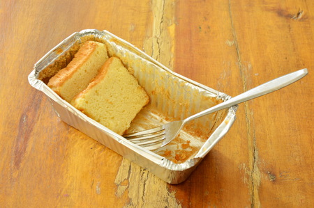 butter cake slice and silver fork in aluminum tray