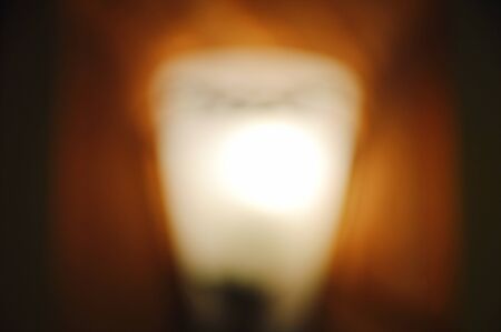 blurry of electric lamp on building wall background and textureの写真素材