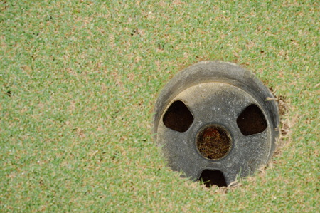 hole on green golf court field in sunny dayの写真素材