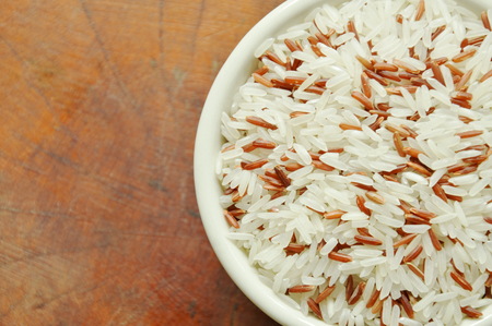 mixed red cargo paddy in bowl on wooden boardの写真素材