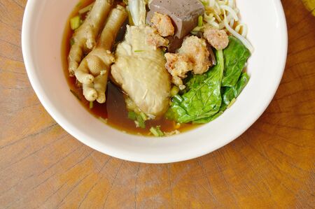 boiled chicken leg and feet with bean sprout in herb brown soup on bowlの写真素材