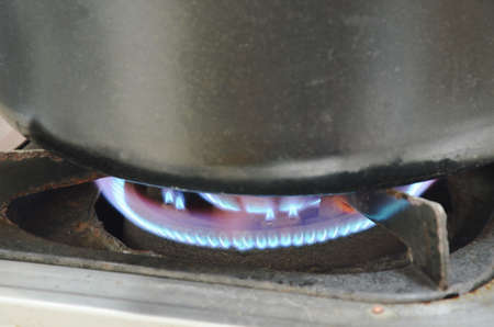 black pot boiled on fire gas stove in kitchen