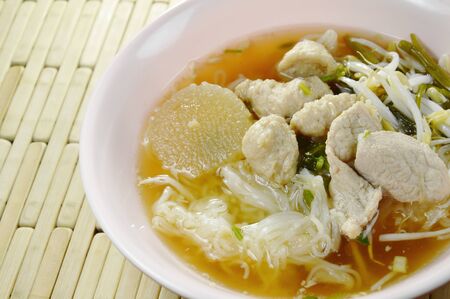 boiled rice noodles topping slice pork and ball in clear soup