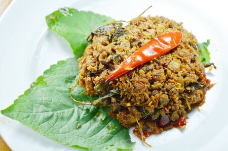 spicy minced fried minced pork with herb on betel leafの写真素材