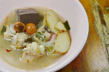 boiled chicken in hot and spicy tom yum soup on bowlの写真素材