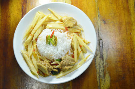 spicy boiled chicken with bamboo shoot in coconut milk curry and rice on plateの写真素材