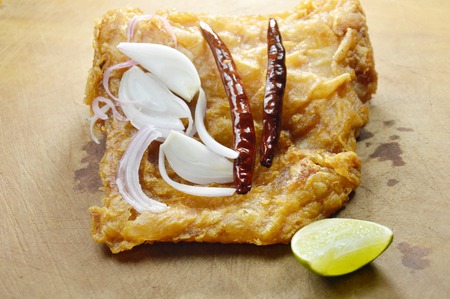 fried pickled fish coated egg with slice shallot and chili