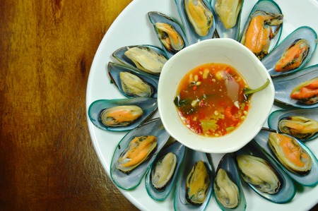 steamed mussel served with spicy sauce on white plate