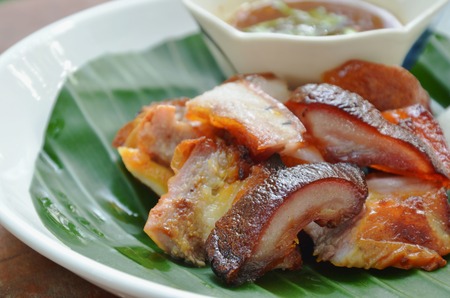 roasted pork belly with sticky rice and dipping spicy sauce on plateの写真素材
