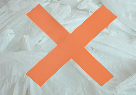 red cross in front of white plastic bag packing stacking on floorの写真素材