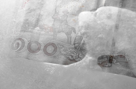 Thai banknote freezing in ice on plastic trayの写真素材