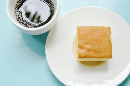 butter cake slice for piece on plate and black coffee cupの写真素材