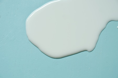 fresh white milk splatter on blue table backgroundの写真素材