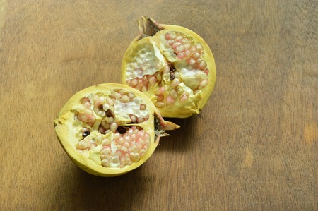Pomegranate tropical fruit half cut on wooden boardの写真素材