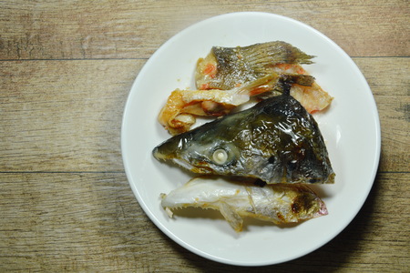 Grilled salmon fish head with soy sauce on plate