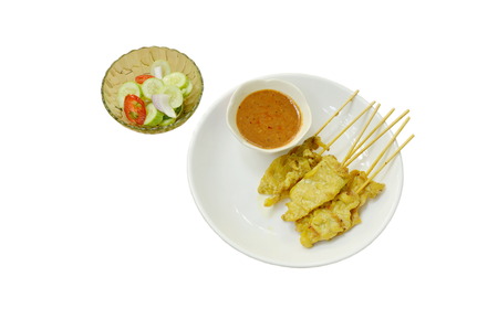 pork satay with peanut sauce and pickled vegetable on white backgroundの写真素材