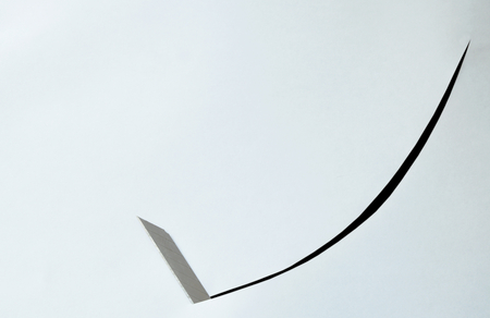 cutter blade curve slashing on white paper backgroundの写真素材