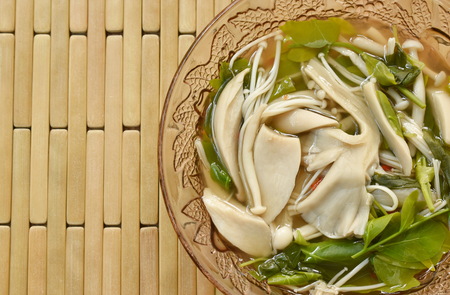 boiled mixed mushroom with star gooseberry in spicy soup  on glass bowl