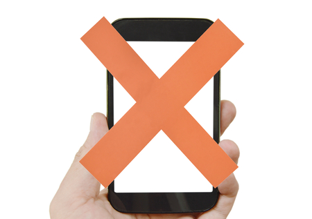 Red cross paper on mobile phone holding in human hand with white backgroundの写真素材
