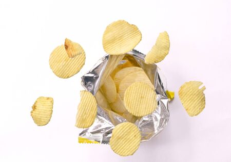potato chip floating over aluminium foil packaging on white backgroundの写真素材