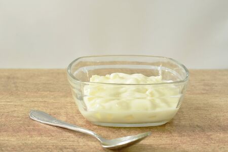 fruit yogurt in glass bowl and silver spoon on tableの写真素材