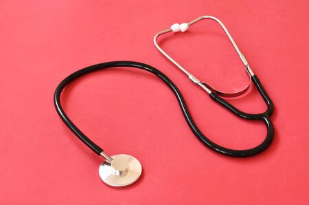 stethoscope medical equipment for doctor listening pulse of patient on red background