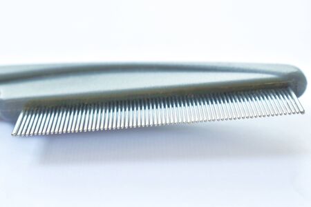 fine teeth comb with red rubber handle for catching ticks or flea to dog and cat on white background