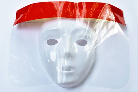 mask wearing plastic face shield for protection coronavirus or COVID -19 on wgite backgroundの写真素材