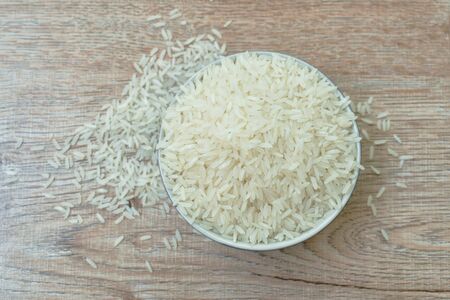 Thai jasmine rice paddy in bowl on wooden tableの写真素材
