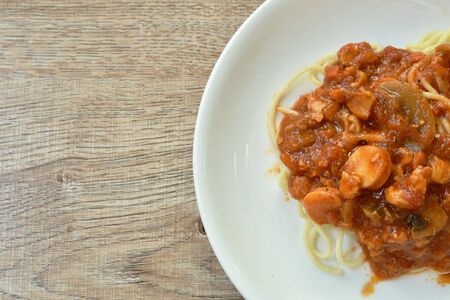 fried spaghetti topping slice sausage with chop pork and ketchup on plateの写真素材