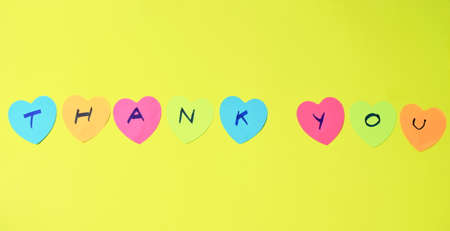 colorful sticky paper note with hearth shape write thank you on yellow foam board backgroundの写真素材