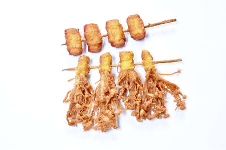 deep fried  Enokitakeor needles mushroom wrapped dumpling flour and bacon stabbing in wooden stick dipping sweet chili sauceの写真素材