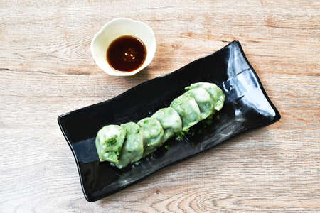 steamed Chinese rice flour dumpling stuffed fried chop garlic chives on plate dipping soy sauceの写真素材