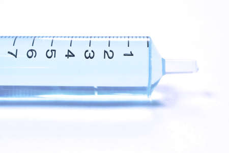 syringe medical equipment with blue liquid vaccine arranging on white backgroundの写真素材