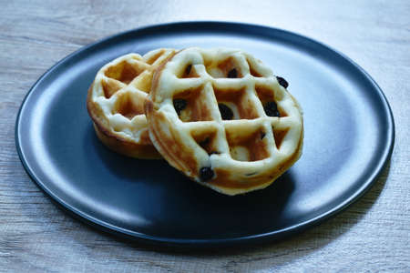 baked circle butter waffle with raisin on plateの写真素材