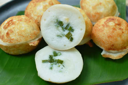 Thai sweetmeat baking coconut pudding topping slice spring onion in banana leaf on dish