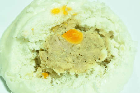 steamed bao Chinese bun stuffing mashed pork and salt egg on white background