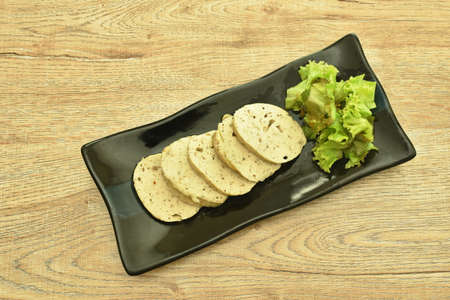 slice steamed mashed  pork and mushroom sausage Vietnamese style with lettuce on plate