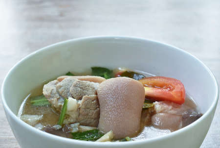 boiled spicy pork leg in tom yum soup on bowlの写真素材