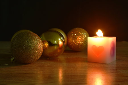 golden ball couple candle light  for decoration in Christmas and new year festival in black backgroundの写真素材