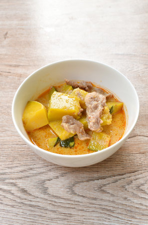spicy boiled pumpkin with slice pork in curry on bowlの写真素材