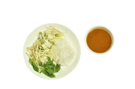 rice noodles dressing fish coconut milk curry sauce and fresh vegetable on plate