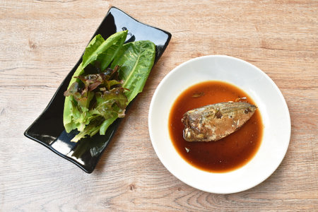 boiled mackerel fish sauce soup on plate with fresh vegetableの写真素材