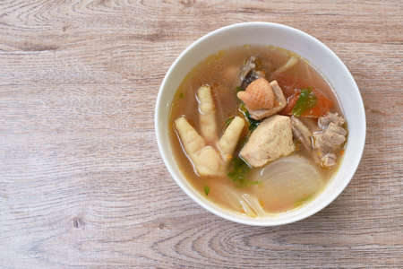 spicy chicken meat and foot in tom yum soup on bowlの写真素材