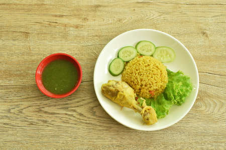 rice cooked with chicken in curry on plate dipping spicy chili sauceの写真素材