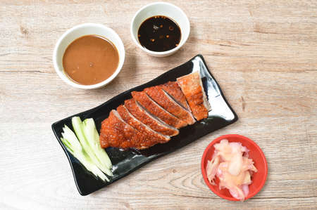 roasted duck meat and pickled ginger dipping sweet soy sauce on plateの写真素材